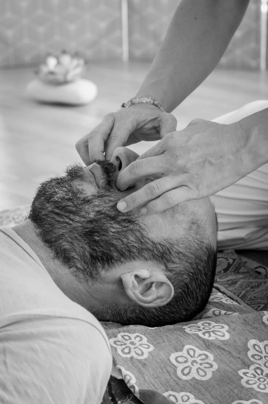 Contact des mains sur le visage pendant une séance de Shiatsu.