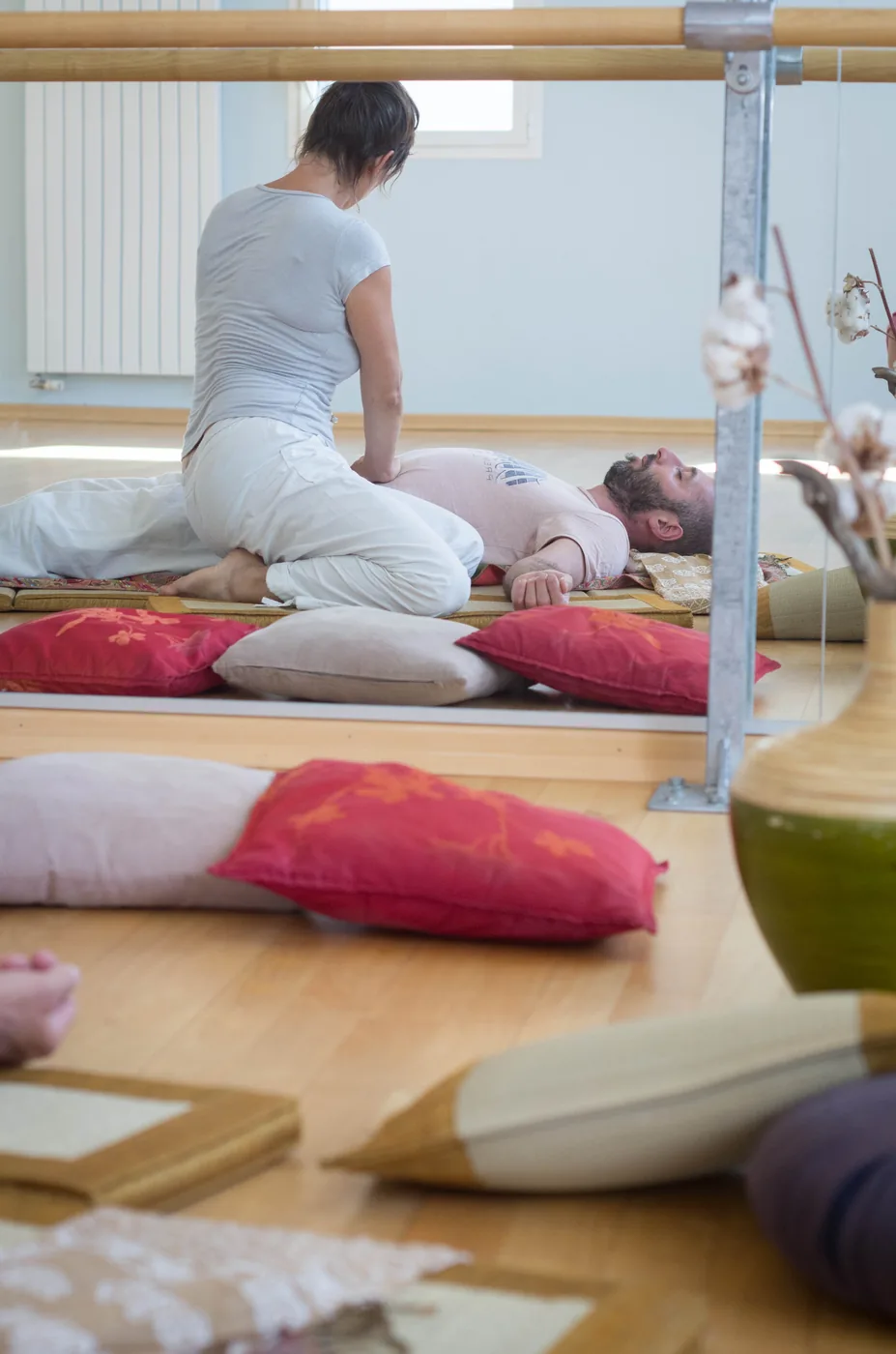Vue de l’espace de pratique avec futons et coussins.