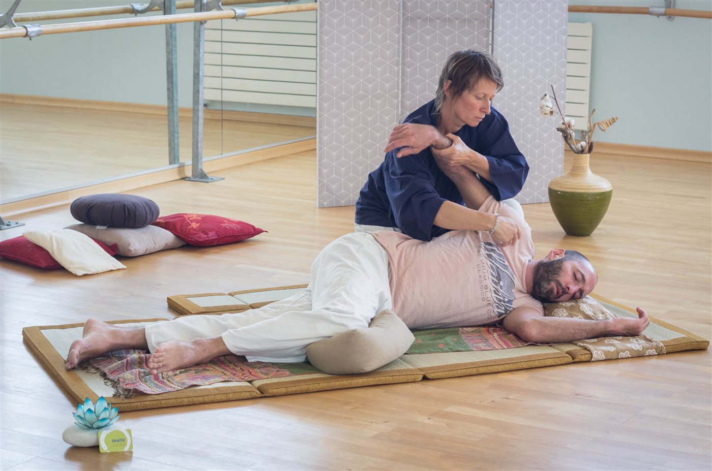 Séverine accompagne une mobilisation du bras pendant une séance de Shiatsu.