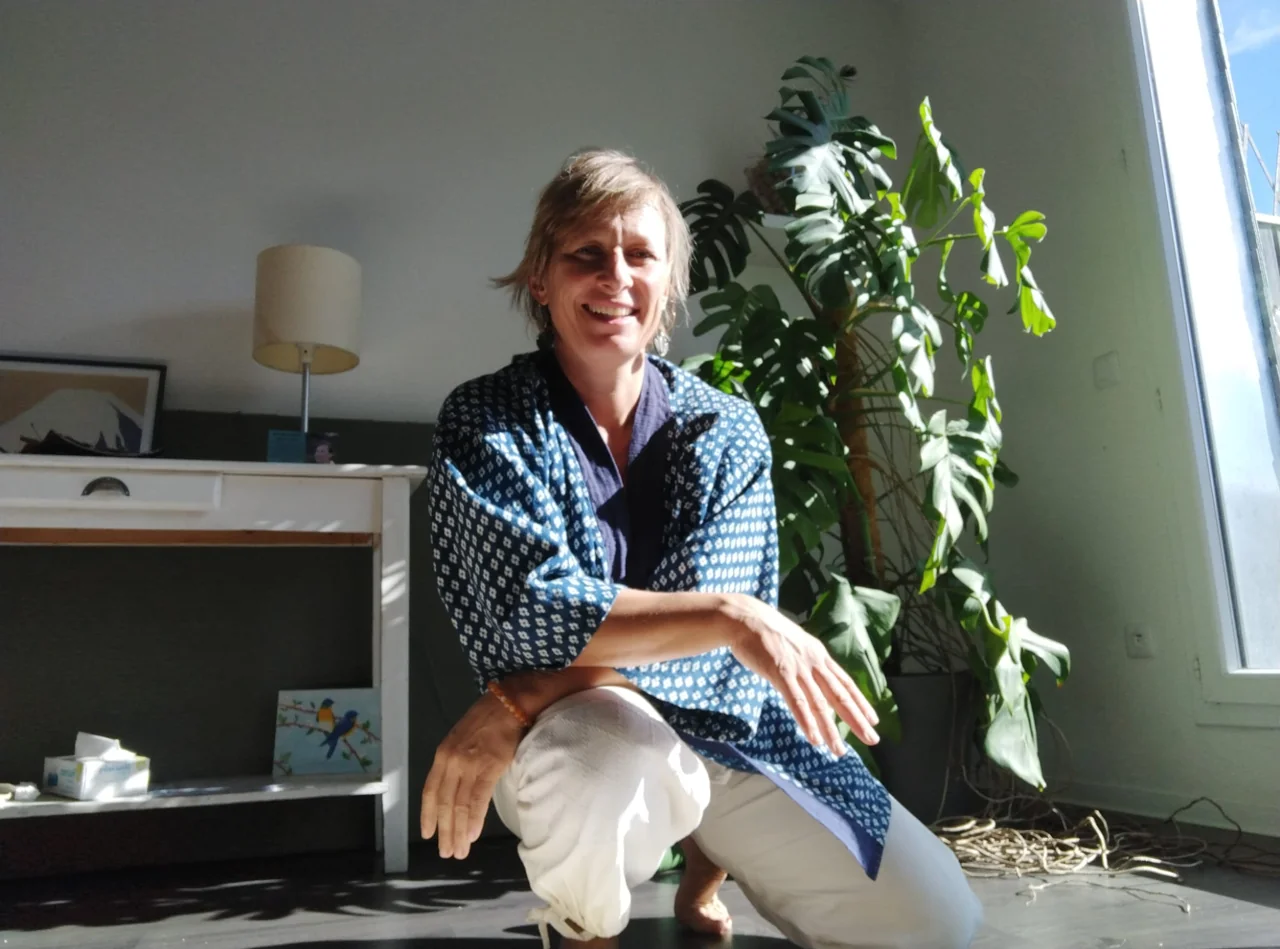 Séverine Moroy, souriante, assise près du futon.