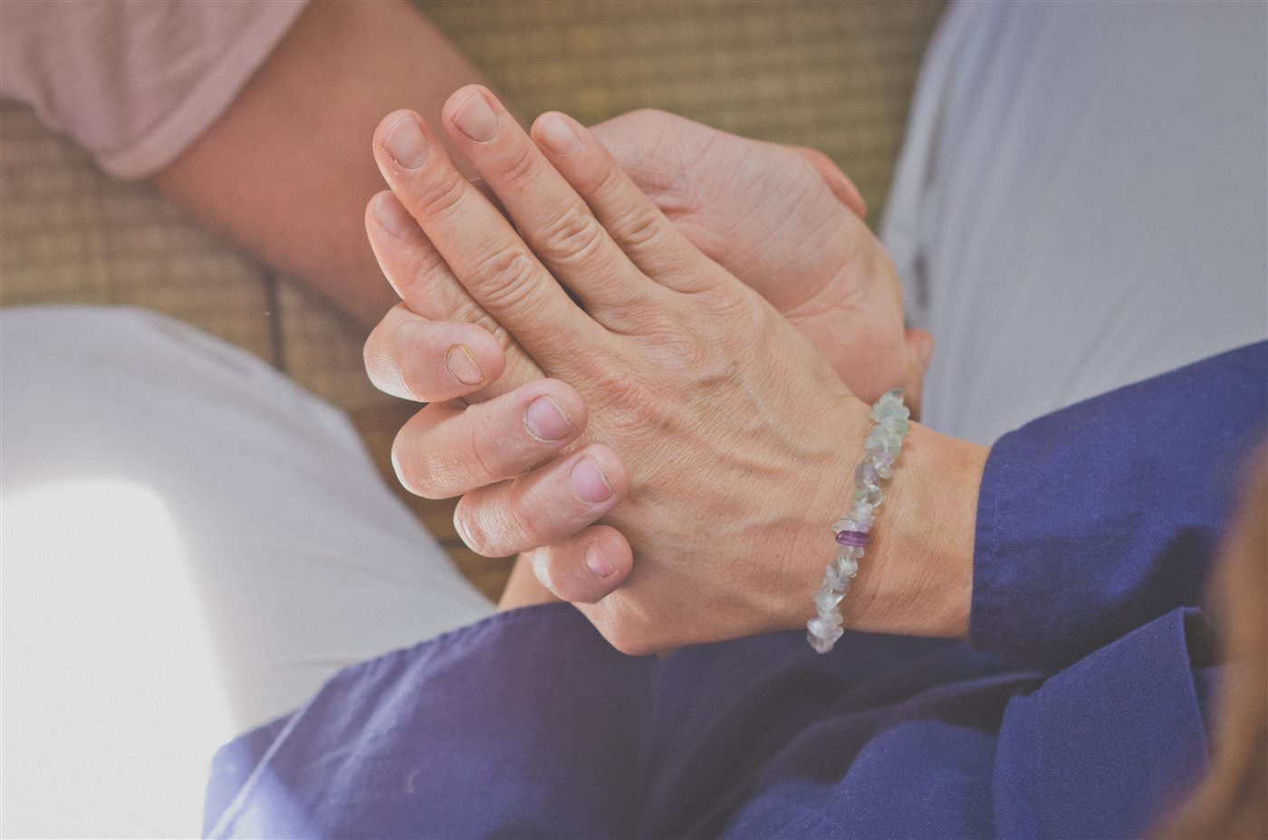 Détail du contact des mains dans une pratique de Shiatsu.